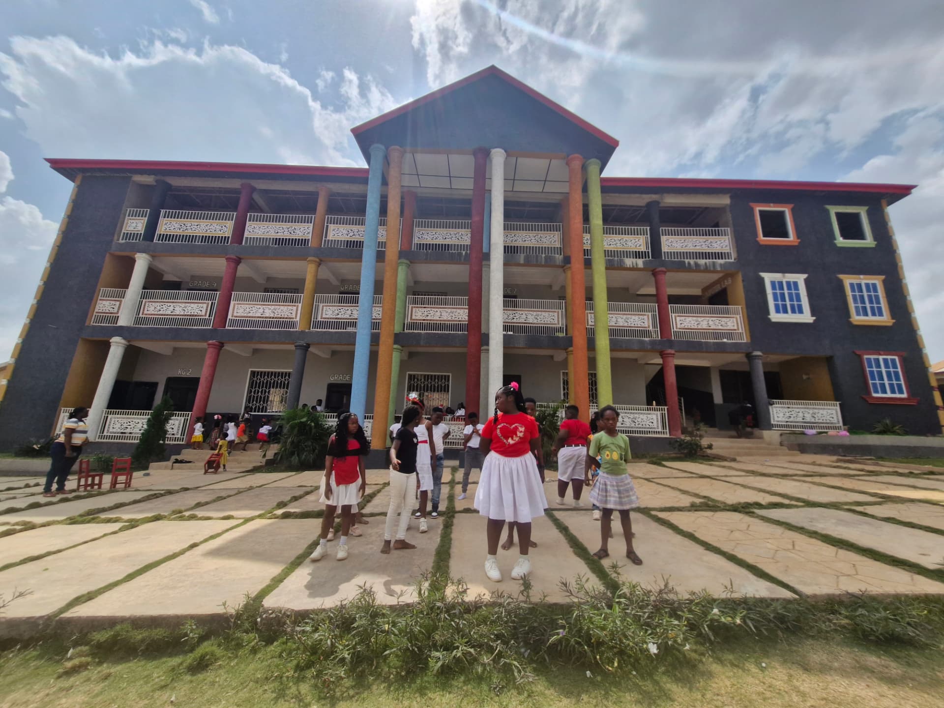 Pupils on the grounds in front of the colourful Main Campus block