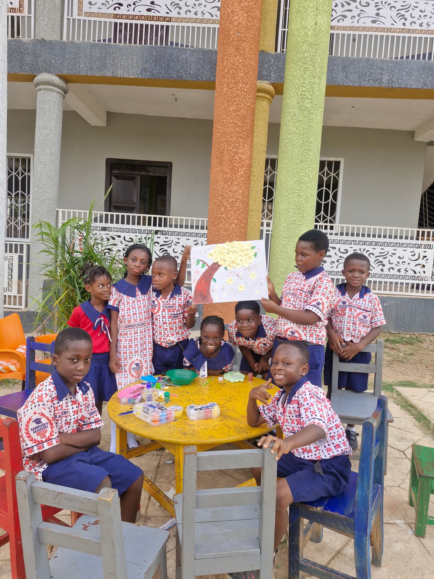 Pupils presenting a painted flower-tree artwork during a creative arts session